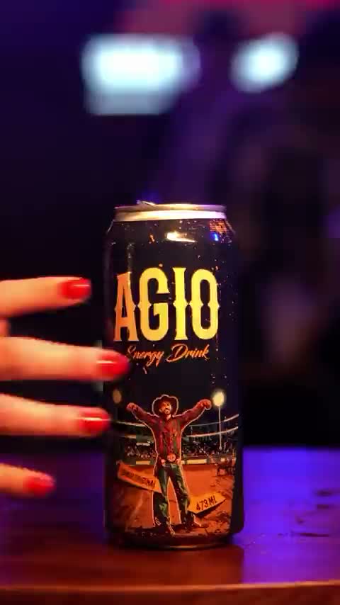 Mãos segurando latas da AGIO no balcão